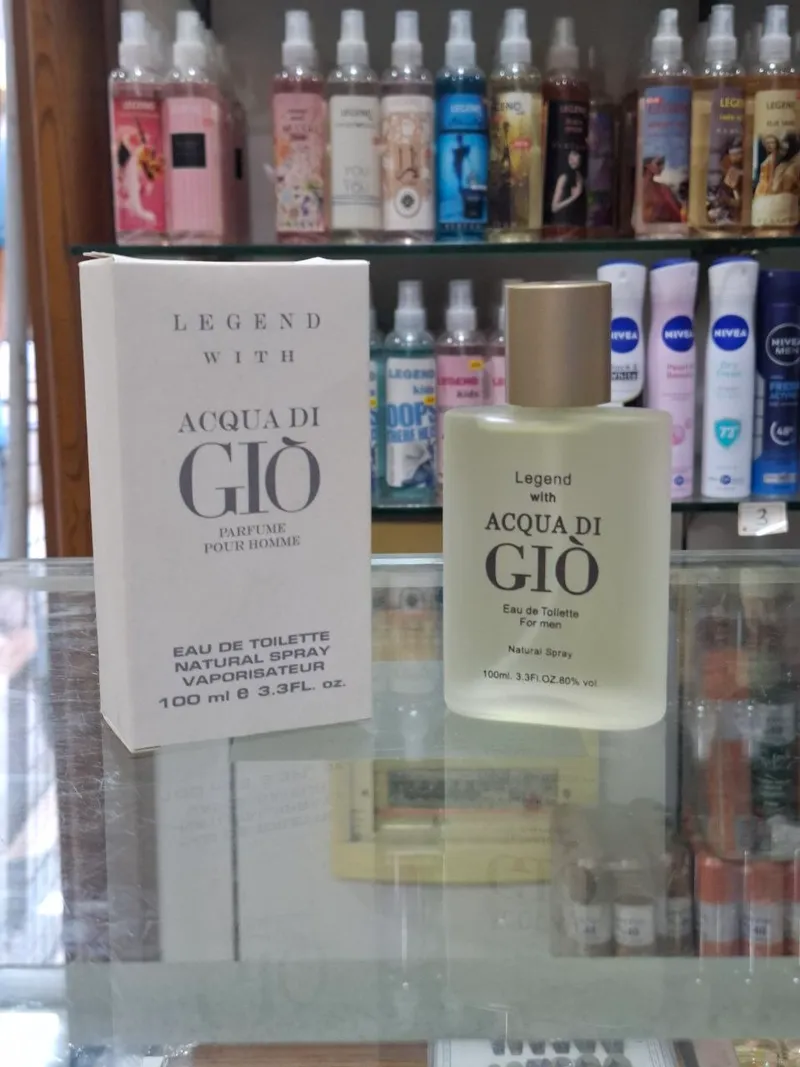 عطر مصوّر بالتلفون عالبنك، والرفوف مبيّنة ورا